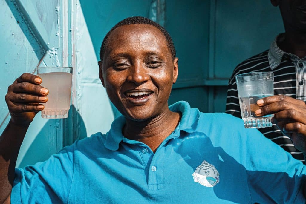 Dr. Hilonga präsentiert Wasser Dr. Hilonga präsentiert den Unterschied zwischen urspünglichem (links) und gefiltertem Wasser (rechts).