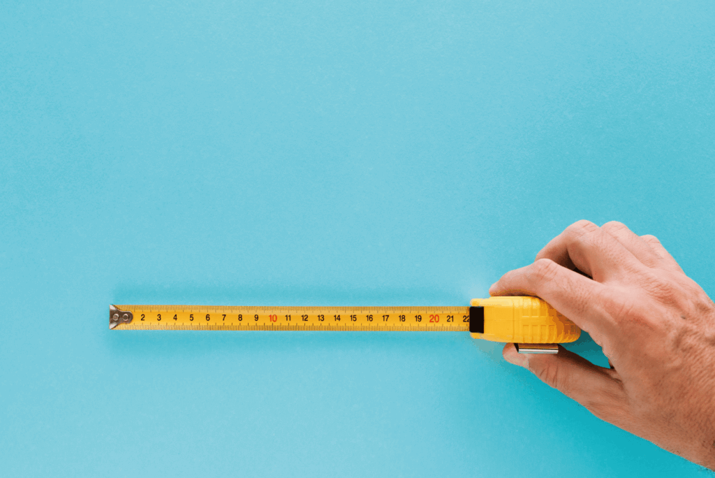 Hand mit ausgezogenen Maßband