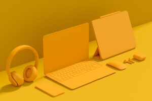 Aluminum laptop with graphic tablet, mouse, headphones and phone on monochrome